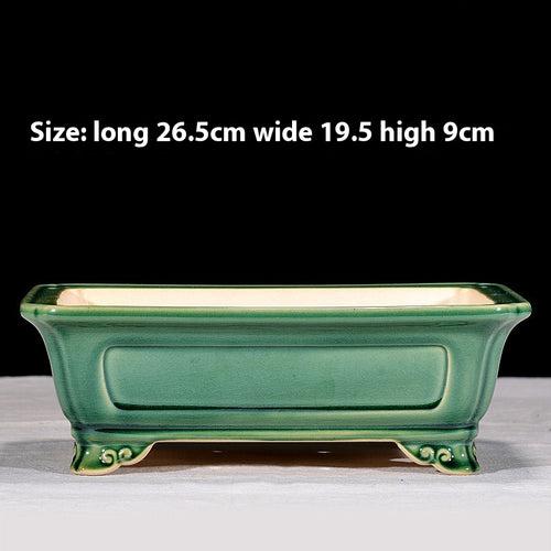 Green rectangular bonsai pot with recessed side panels and curled feet, with dimensions above