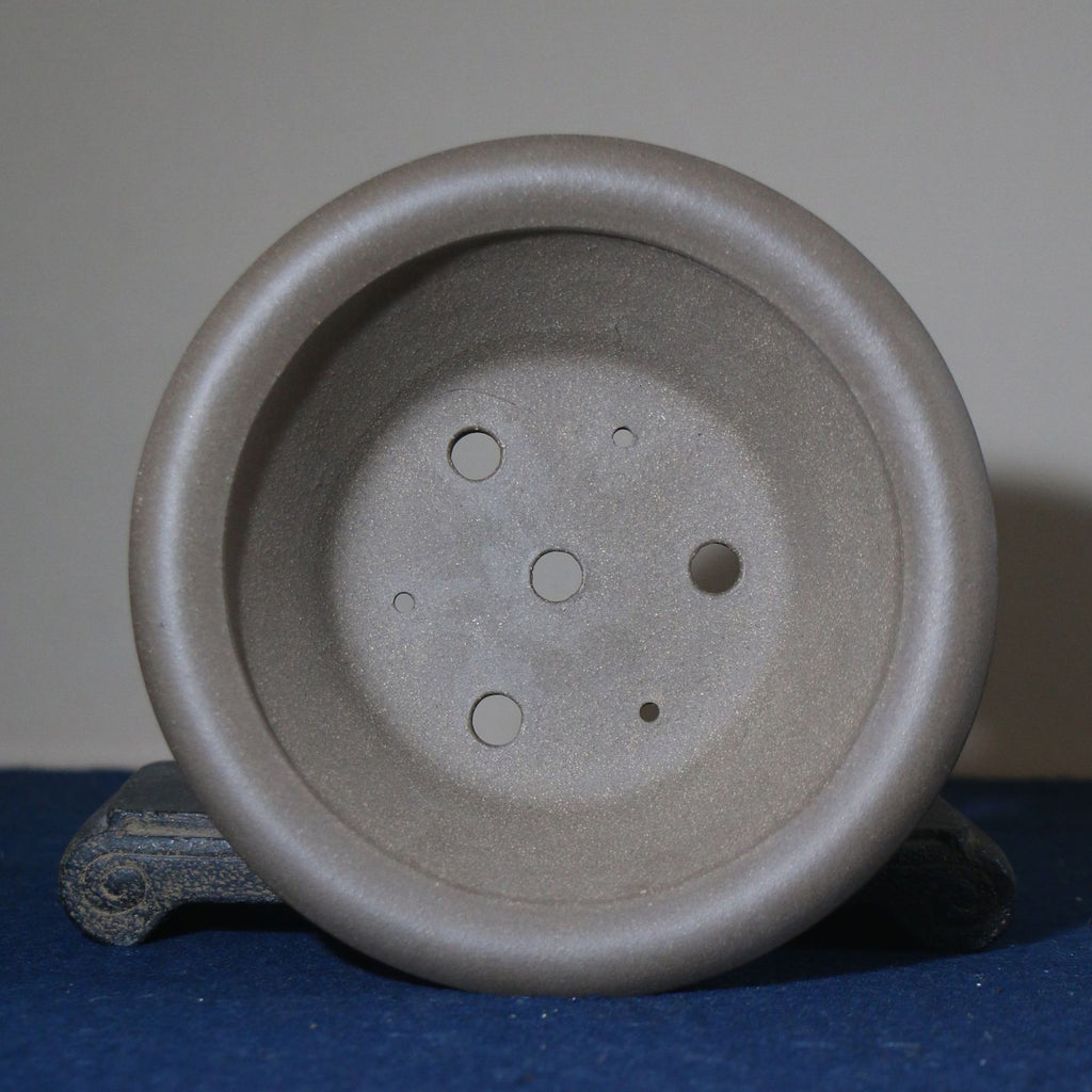 Top view of gray round pot showing base openings and circular recesses