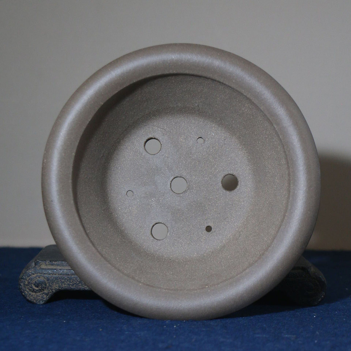 Top view of gray round pot showing base openings and circular recesses