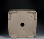 Underside of taupe square pot showing central opening, corner feet and stamped marks