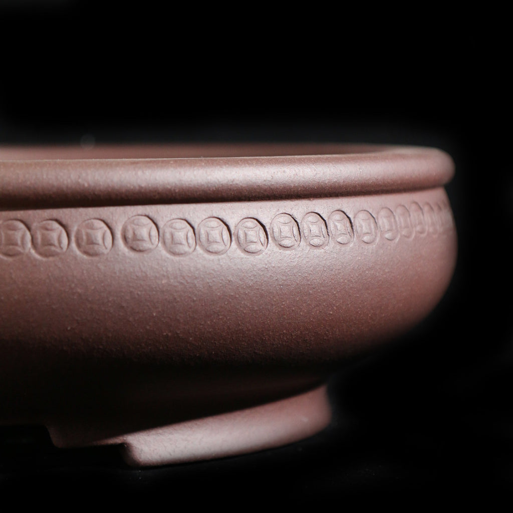 Close-up of the round pot's coin-like motif band