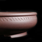Close-up of the round pot's coin-like motif band
