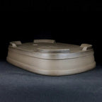 Upside-down taupe pot showing feet and banded walls
