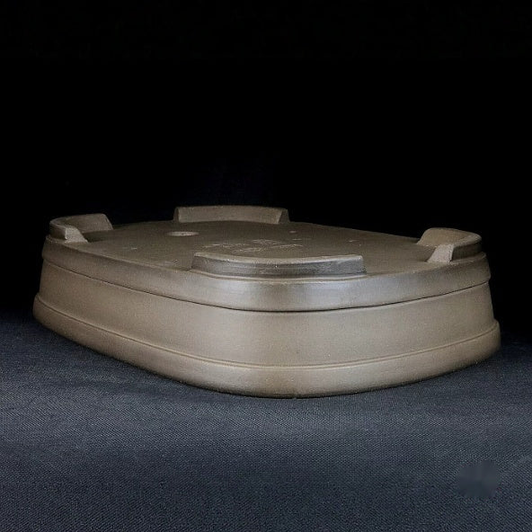 Upside-down taupe pot showing feet and banded walls