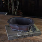 Dark brown lobed rectangular pot with scalloped rim and paneled walls