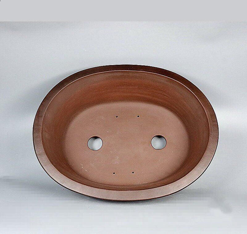 Top view of large brown oval pot showing two large openings and small holes