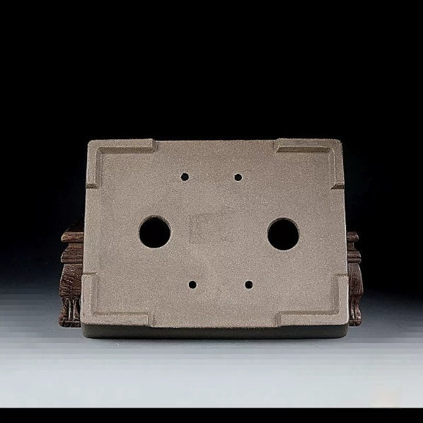 Underside of taupe rectangular pot showing two large openings and four small holes