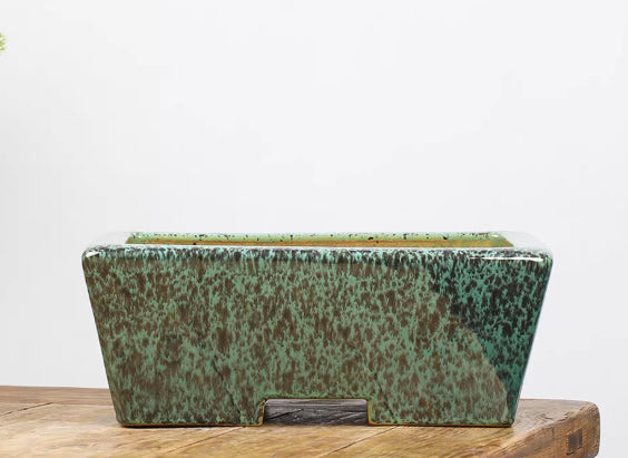 Angled green mottled rectangular pot showing notched base