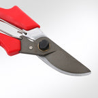 Close-up of the shears' dark blade, pivot bolt and red handle