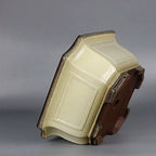 Angled underside view of the cream-glazed square pot with dark clay base