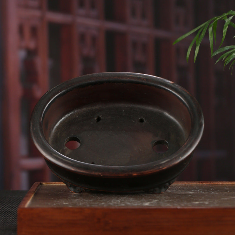 Dark-brown oval pot interior with drainage openings