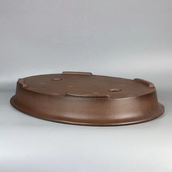 Upside-down brown oval pot showing base profile and feet
