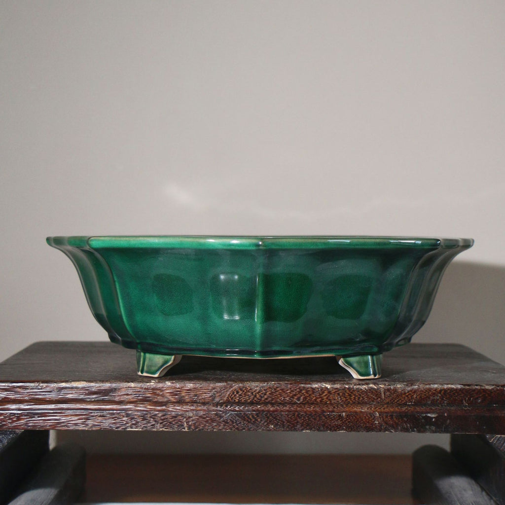 Front view of the emerald-green pot on a wooden stand