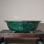 Front view of the emerald-green pot on a wooden stand