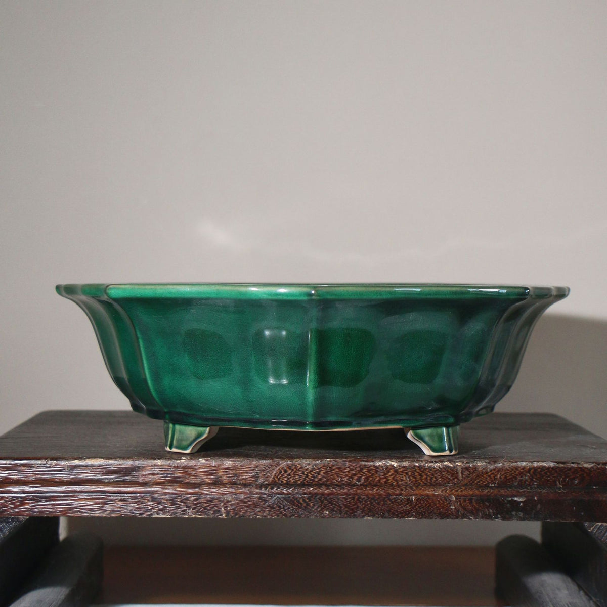 Front view of the emerald-green pot on a wooden stand