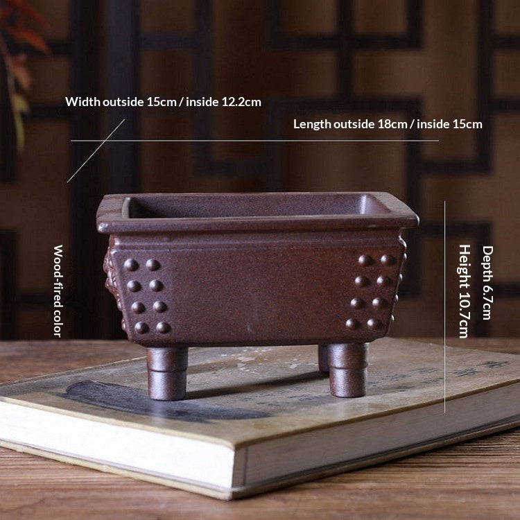 Brown rectangular bonsai pot with studded corners and tall feet, with exterior and interior measurement labels