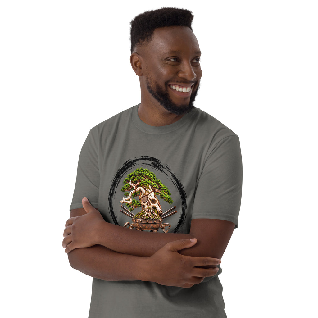 Model wearing charcoal gray T-shirt with green bonsai and pirate skull graphic inside a black circle with Bonsai Life Co. lettering, arms-crossed close view
