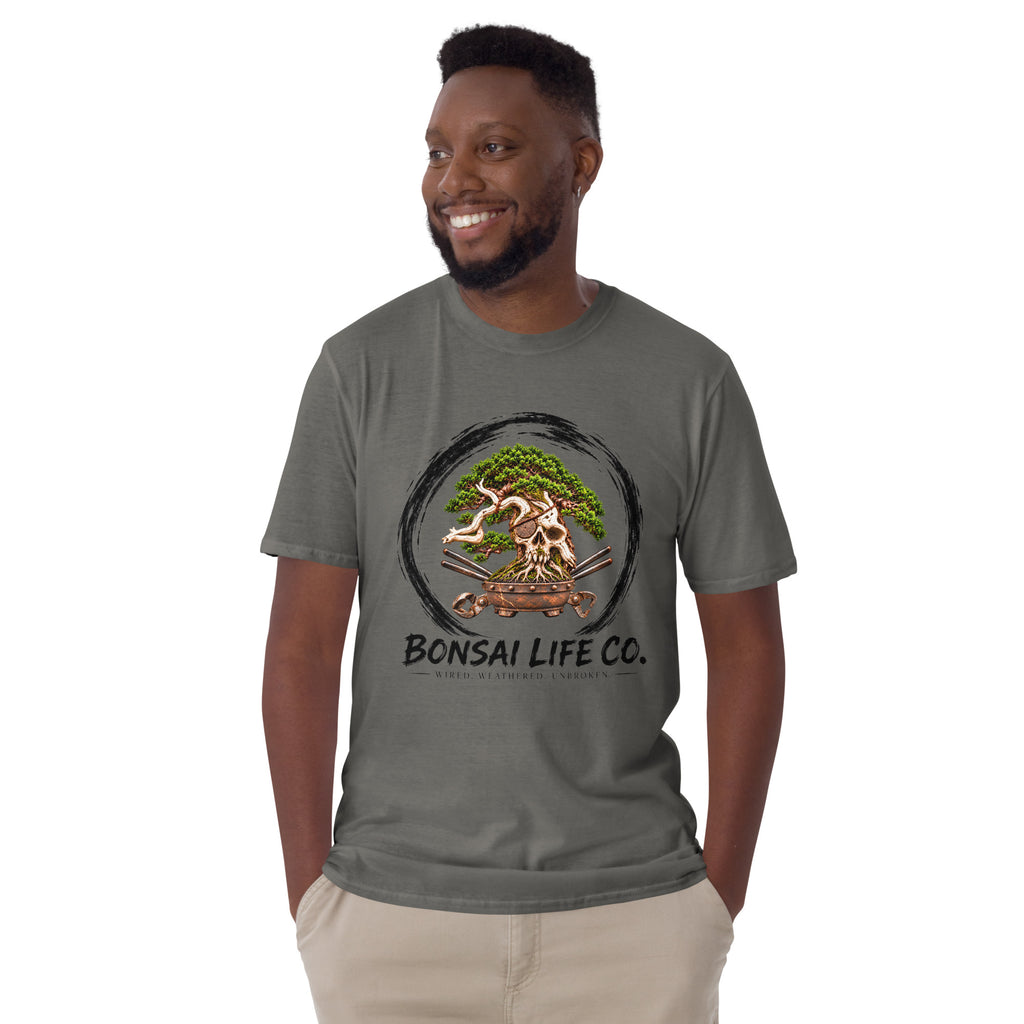 Model wearing charcoal gray T-shirt with green bonsai and pirate skull graphic inside a black circle with Bonsai Life Co. lettering, front view
