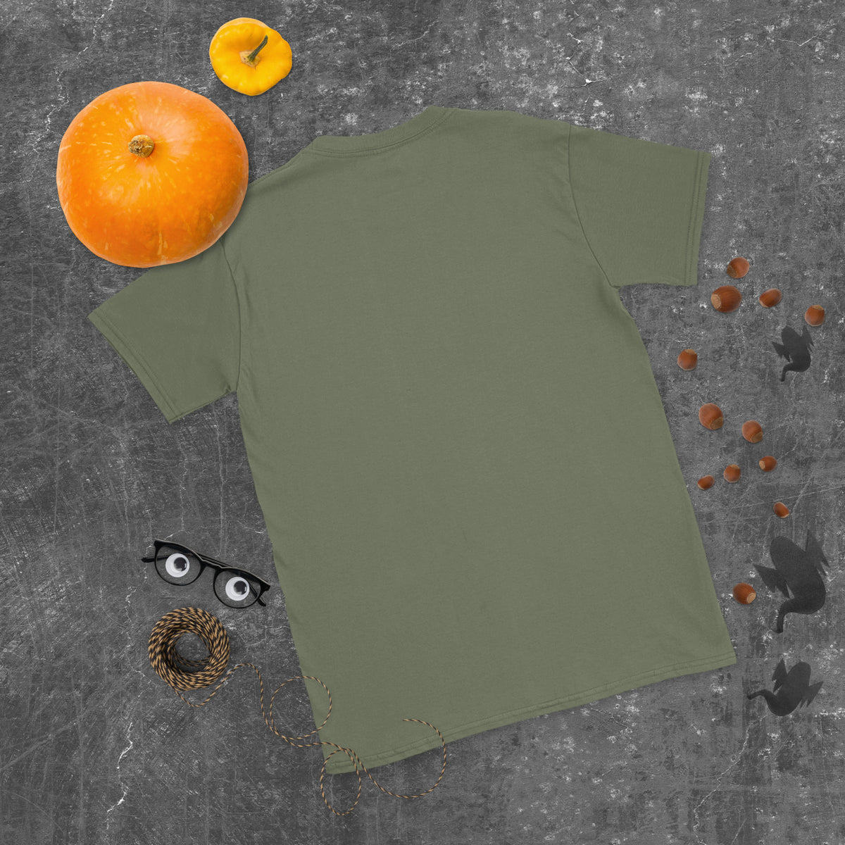 Plain back of muted olive green Bonsai Life Co. T-shirt in a gray flat lay with pumpkins