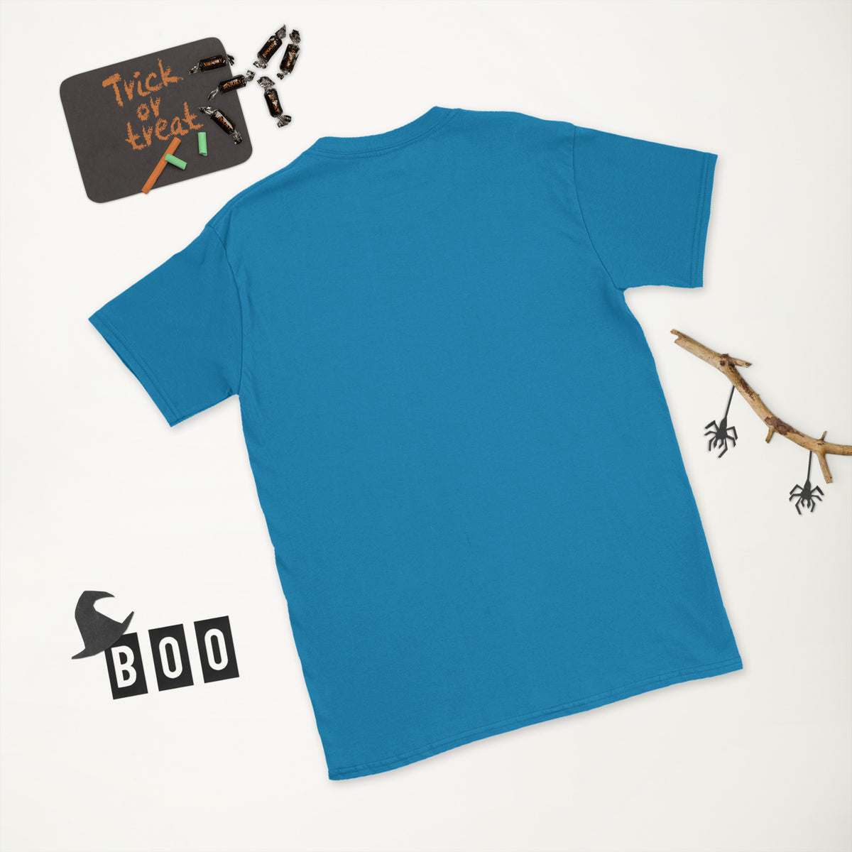 Plain back of sapphire blue Bonsai Life Co. T-shirt in a white Halloween flat lay