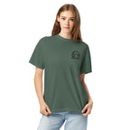 Model wearing muted blue-green T-shirt with small circular Three Trees chest logo, closer front view