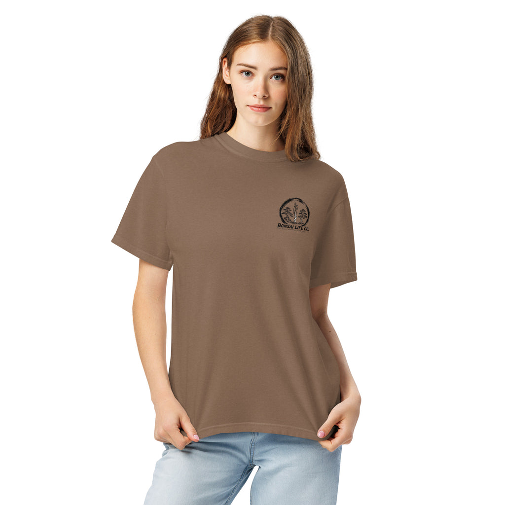 Model wearing brown T-shirt with small circular Three Trees chest logo, closer front view