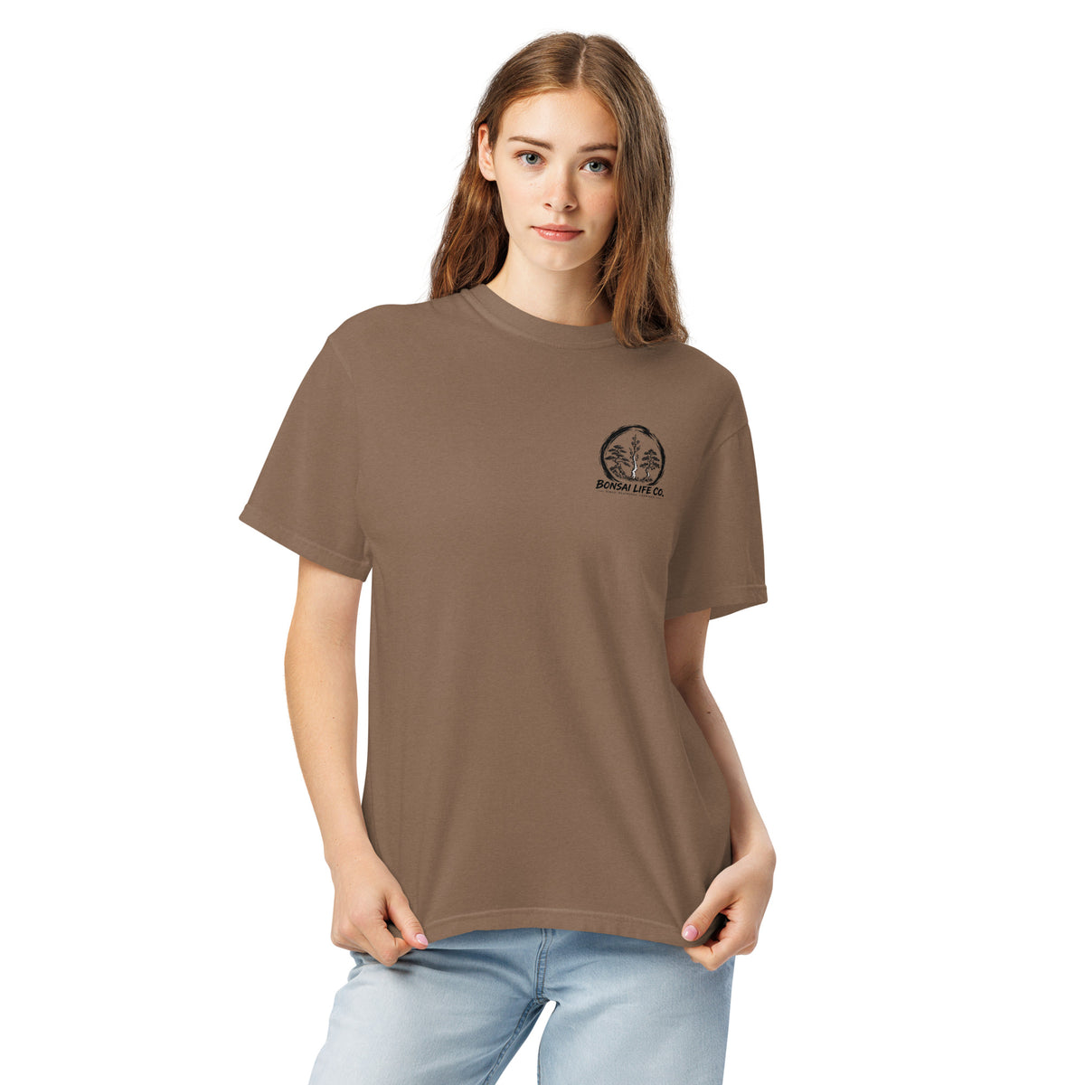 Model wearing brown T-shirt with small circular Three Trees chest logo, closer front view