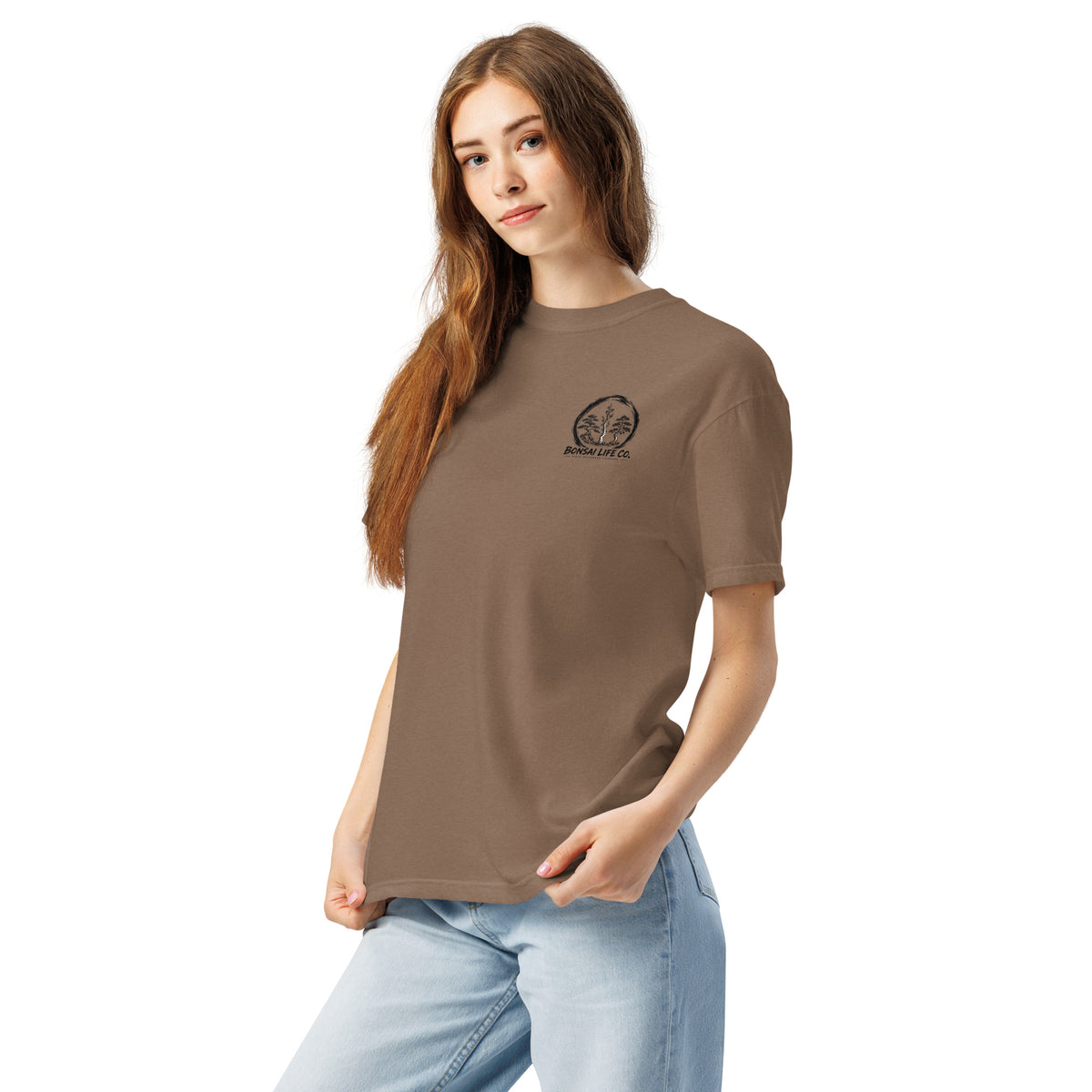 Model wearing brown T-shirt with small circular Three Trees chest logo, angled front view