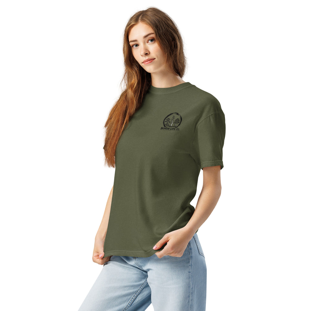 Model wearing olive green T-shirt with small circular Three Trees chest logo, angled front view