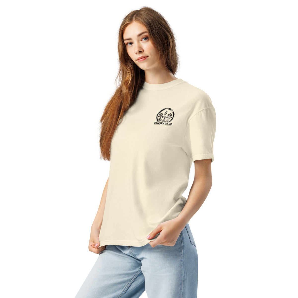 Model wearing ivory T-shirt with small circular Three Trees chest logo, angled front view