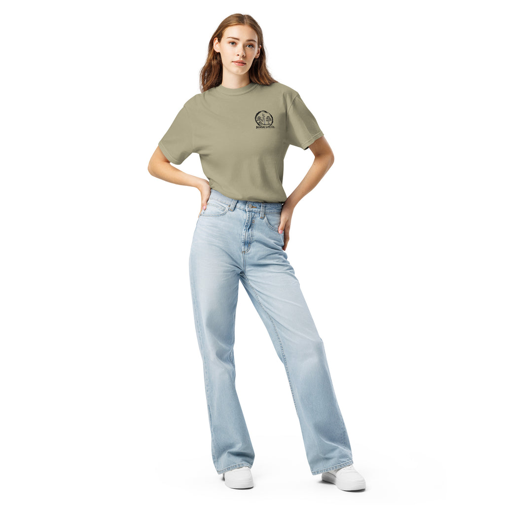 Model wearing khaki beige T-shirt with small circular Three Trees chest logo, full-length front view