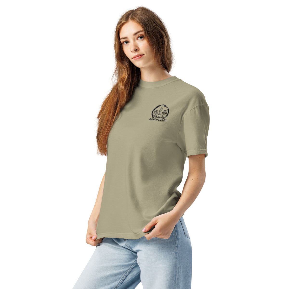 Model wearing khaki beige T-shirt with small circular Three Trees chest logo, angled front view