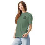 Model wearing sage green T-shirt with small circular Three Trees chest logo, angled front view