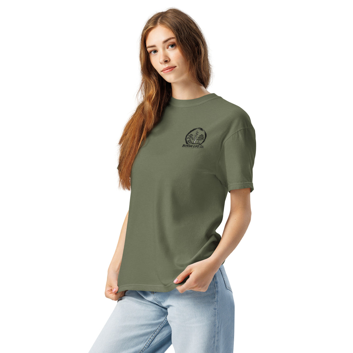 Model wearing moss green T-shirt with small circular Three Trees chest logo, angled front view