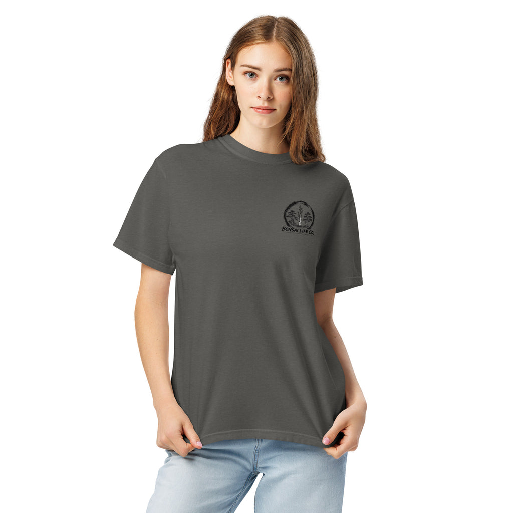 Model wearing washed charcoal gray T-shirt with small circular Three Trees chest logo, closer front view