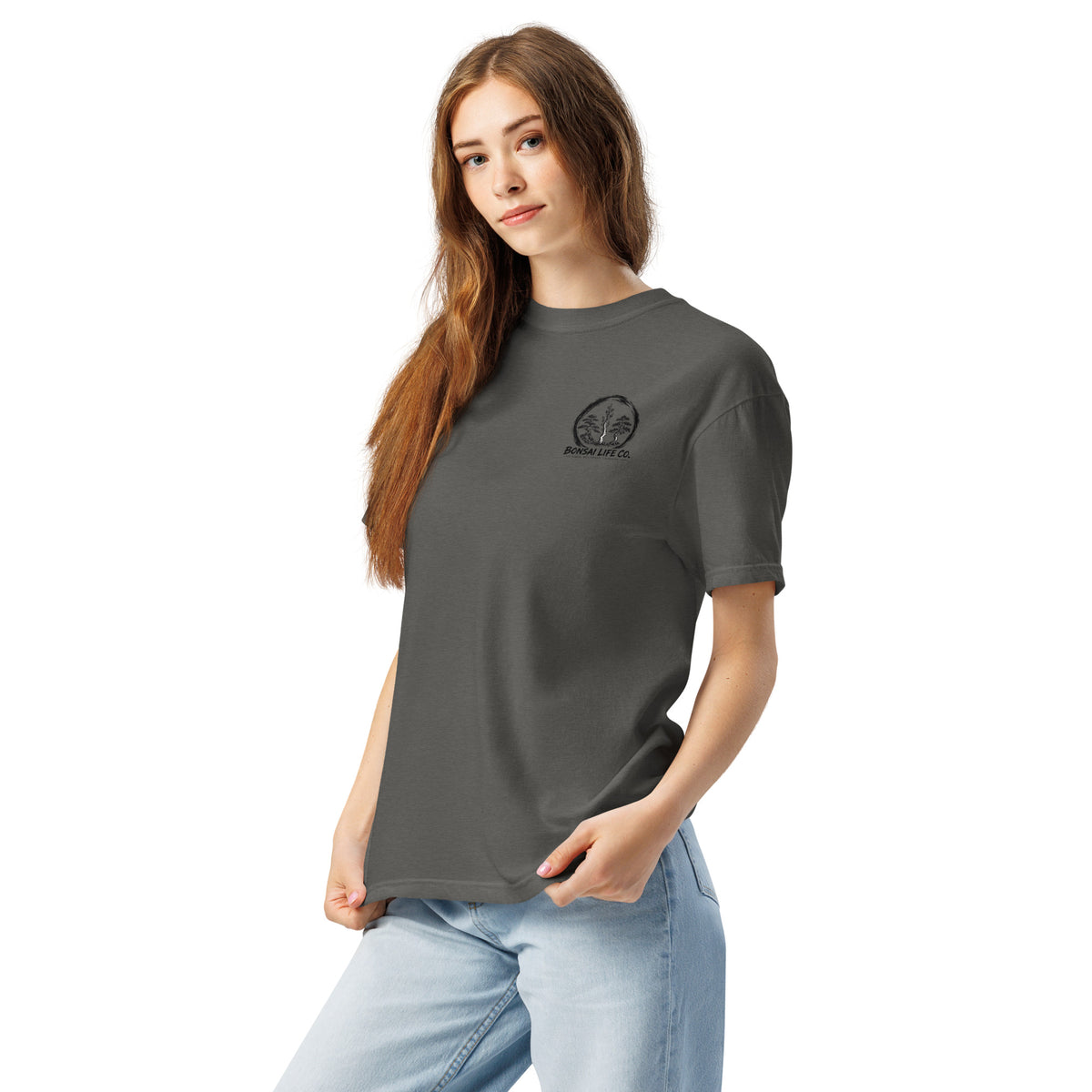 Model wearing washed charcoal gray T-shirt with small circular Three Trees chest logo, angled front view