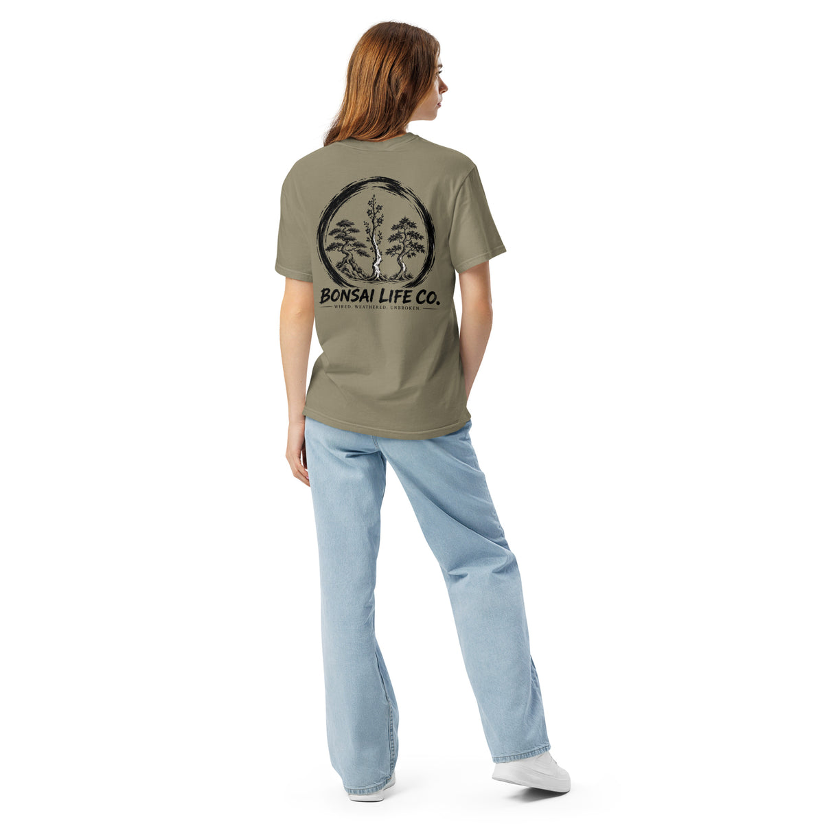 Model showing back of gray-beige T-shirt with large black Three Trees circle and Bonsai Life Co. lettering