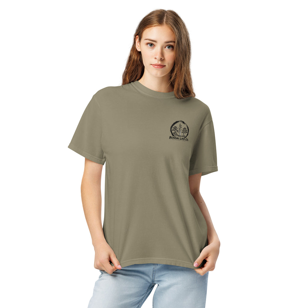 Model wearing gray-beige T-shirt with small circular Three Trees chest logo, closer front view