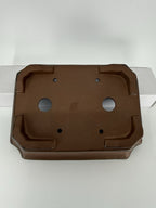 Underside of the brown rectangular pot showing four corner feet, drainage openings and an impressed seal